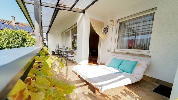 Un dormitorio con cama, ventana y vistas a un jardín.