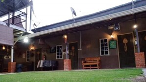 A building with a covered outdoor area, a brick wall, and a grassy lawn. - OYO Home 90426 Kepayan Dnd Stay (Kota Kinabalu)