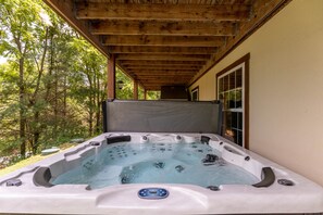 A hot tub under a wooden pergola with a view of trees. - Lazy Bear Inn: Hot Tub | Dog Friendly Fenced Yard | Sugar Grove Privacy (Sugar Grove)