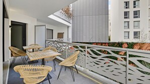 A balcony with wicker furniture and a white railing.
