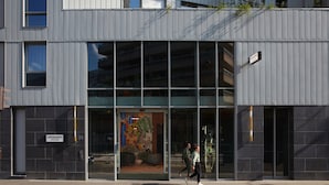 A modern building with large glass windows and a sign indicating a drawing house. - Drawing House (Paris)