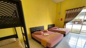 Quarto com duas camas, incluindo uma beliche, e uma janela com cortinas.