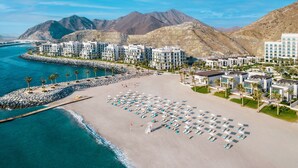 A coastal hotel with multiple buildings, a sandy beach, and a rocky shoreline. - Address Beach Resort Fujairah (Al Aqah)