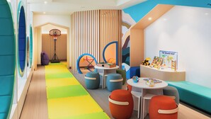 A children's play area with colorful seating, a basketball hoop, and educational toys. - Address Beach Resort Fujairah (Al Aqah)