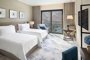 A hotel room with two beds, a chair, a small table, and a TV. - Address Beach Resort Fujairah (Al Aqah)