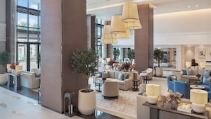 A spacious lobby with multiple seating areas, large windows, and modern lighting fixtures. - Address Beach Resort Fujairah (Al Aqah)