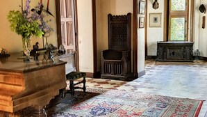 A traditional room with a large patterned rug, wooden furniture, and a decorative wall. - L'abeaupinière (Reboursin)