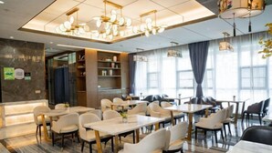 A modern dining area with marble flooring, white and black chairs, and a chandelier. - Vienna International Hotel (Dongguan Hongmei Town) (Dongguan)