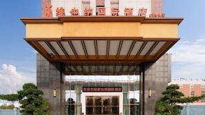 A hotel entrance with a modern design, featuring a prominent entrance canopy and glass doors. - Vienna International Hotel (Dongguan Hongmei Town) (Dongguan)