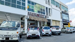 Un immeuble à plusieurs étages avec un parking situé à l’avant.