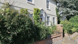 A two-story house with a brick wall and a stone staircase leading to the entrance. - Dunham House | Celebrations| Families & Friends| Parking | Dogs (Dunham on Trent)