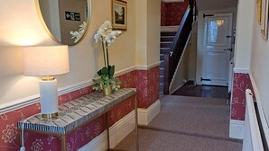 A hallway with a mirror, a potted plant, a lamp, and a staircase. - Dunham House | Celebrations| Families & Friends| Parking | Dogs (Dunham on Trent)