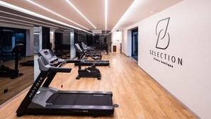 A modern fitness boutique with treadmills, a wall-mounted logo, and a clean, wooden floor.