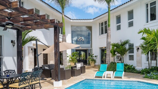 A pool area with lounge chairs, a table, and a pergola. - Amazing Private Villa with Chef & Maids (Punta Cana)