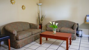 A living room with two sofas, a coffee table, and decorative wall art.