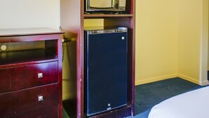 A compact kitchenette with a microwave and a small refrigerator.