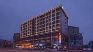 A multi-story hotel with a modern design, featuring a prominent entrance with signage and a series of windows on the facade. - Vienna Hotel (Yudu Railway Station) (Yudu)