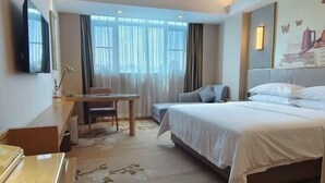 A hotel room with a bed, a desk, a chair, a television, and a window with curtains. - Vienna Hotel (Yudu Railway Station) (Yudu)