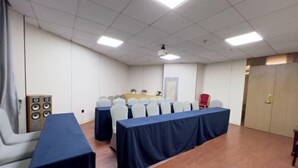A conference room with a long table, chairs, a projector, and a speaker system. - Jiangmen Park Lane Yiju Hotel (Wuyi University Baishi) (Jiangmen)