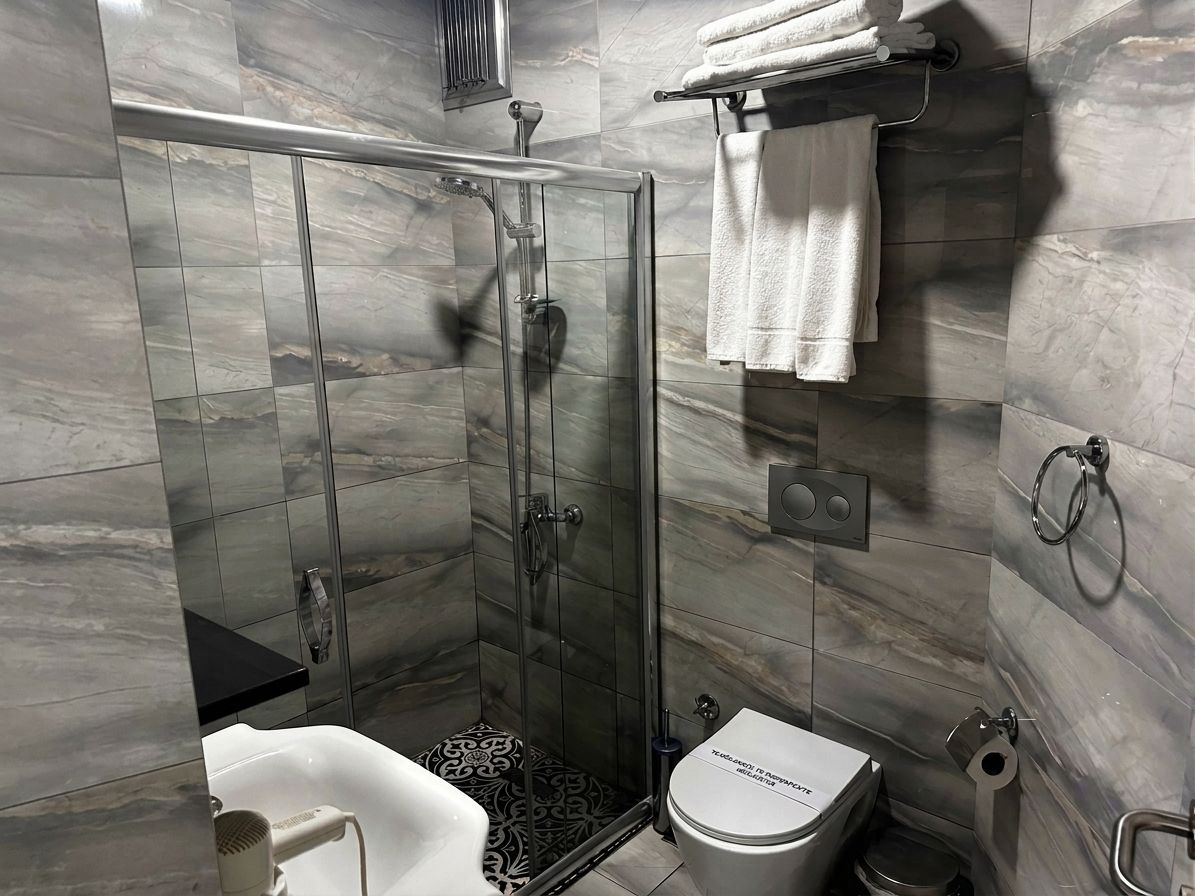 Un baño moderno con ducha envuelta en vidrio, inodoro y lavamanos.
