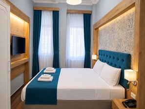 A hotel room with a large bed, a flat-screen TV, a wooden headboard, and a patterned wallpaper. - Miss City Hotel Taksim (Istanbul)
