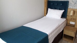A single bed with a white mattress and a teal throw blanket. - Miss City Hotel Taksim (Istanbul)