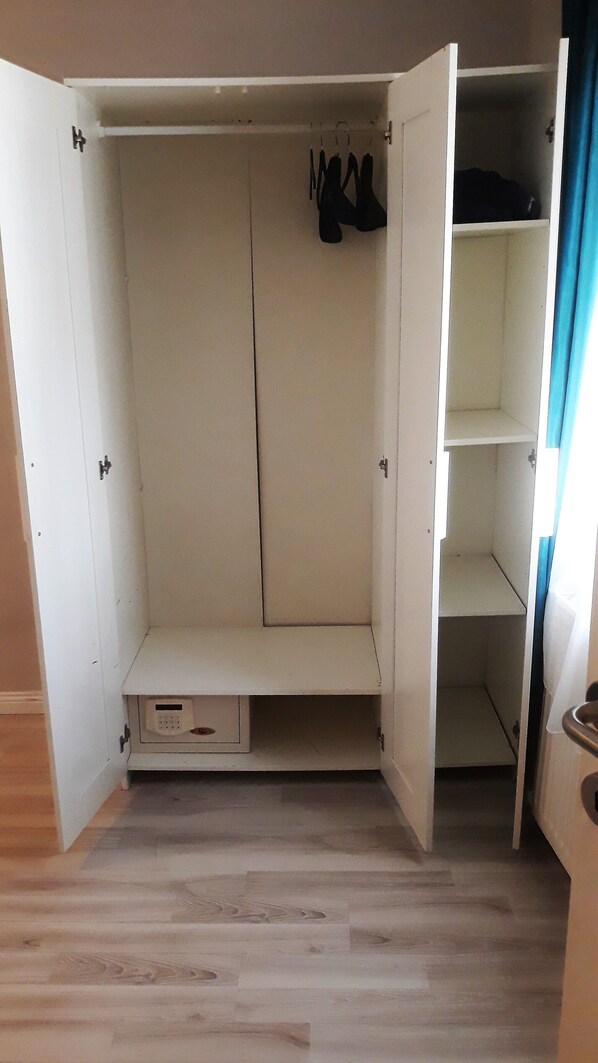 A walk-in closet with open doors, a hanging rod, and a small drawer unit. - Miss City Hotel Taksim (Istanbul)