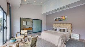 Een moderne slaapkamer met een groot bed, een houten hoofdbord, een bank en een eettafel.