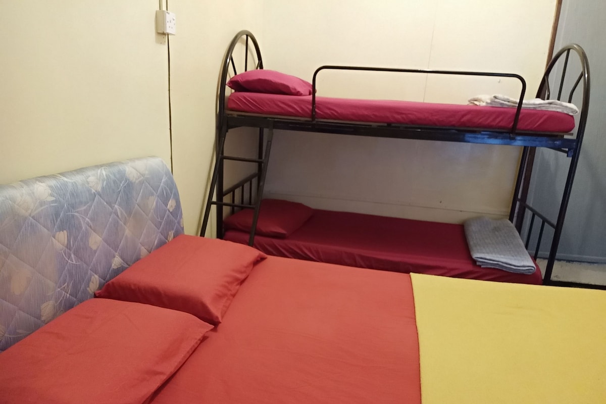 Una cama litera con ropa de cama roja y un cabecero estampado en azul.