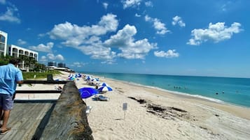 Enjoy sunbathing and relaxation on the sandy beach, where umbrellas offer shade and the ocean beckons for a refreshing swim.