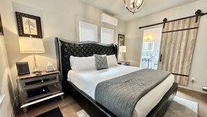 Une chambre d’hôtel bien aménagée, avec un grand lit, des tables de chevet, un bureau et une armoire.