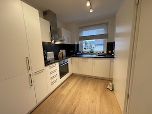 Enjoy cooking in this well-lit kitchen with an oven and large window offering a view of the outdoors.