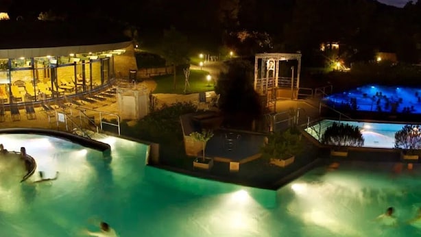A swimming pool area with multiple pools and a covered seating area. - Shopping, vacation or business - you've finally come to the right place (Metzingen)
