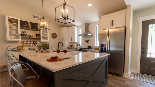 A modern kitchen with a central island, stainless steel appliances, and a chandelier. - Beautiful 4/3 waterfront home with 2 master suites (Tool)