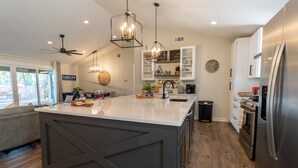 A modern kitchen with a large island, stainless steel appliances, and pendant lighting. - Beautiful 4/3 waterfront home with 2 master suites (Tool)