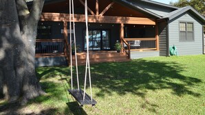 A house with a porch, a swing, and a small shed. - Beautiful 4/3 waterfront home with 2 master suites (Tool)