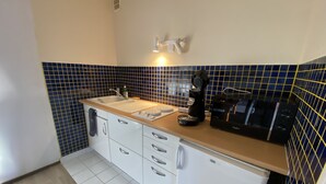 A compact kitchen with a sink, countertop, and a coffee machine. - Studio at the foot of the slopes Laguiole resort (Laguiole)