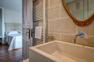 A bathroom with a bathtub, a mirror, and a towel rack.