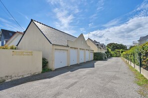 A row of single-story buildings with a gravel driveway, a sign reading 'Les Pauls,' and a clear blue sky. - Les Saules - Proche plage - Terrasse (Pornichet)