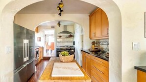 Een keuken met houten kasten, een centraal eiland en uitzicht op de eetruimte.
