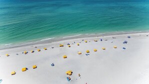 A beach with white sand and clear turquoise water.