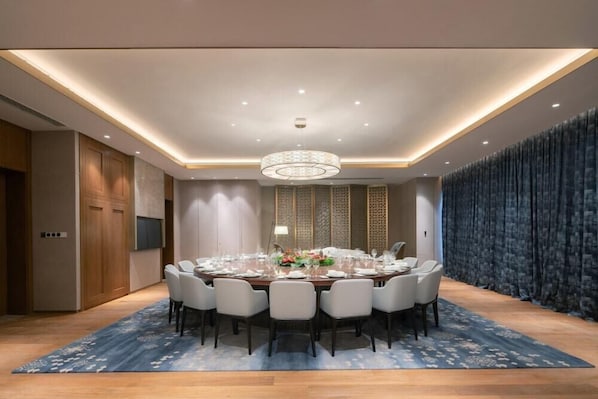 Un comedor moderno con una mesa redonda dispuesta para seis personas, rodeada de sillas.