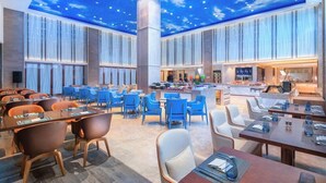 A spacious hotel lobby with a starry ceiling, multiple seating areas, and a central bar. - Fly Zoo Hotel (Hangzhou)