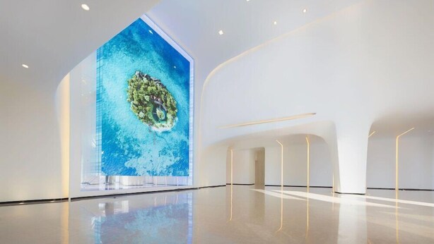 A spacious, modern interior with a large digital display of a tropical island. - Fly Zoo Hotel (Hangzhou)