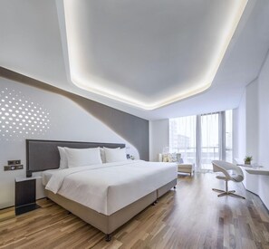 A modern bedroom with a large bed, bedside tables, a desk, and a chair. - Fly Zoo Hotel (Hangzhou)