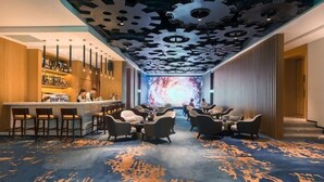 A modern lounge area with a bar, seating, and a unique ceiling design. - Fly Zoo Hotel (Hangzhou)