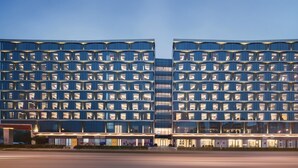 A modern hotel with a grid-like facade, multiple balconies, and a flat roof. - Fly Zoo Hotel (Hangzhou)