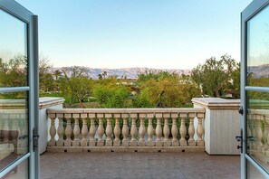 A balcony with a balustrade overlooking a mountainous landscape.