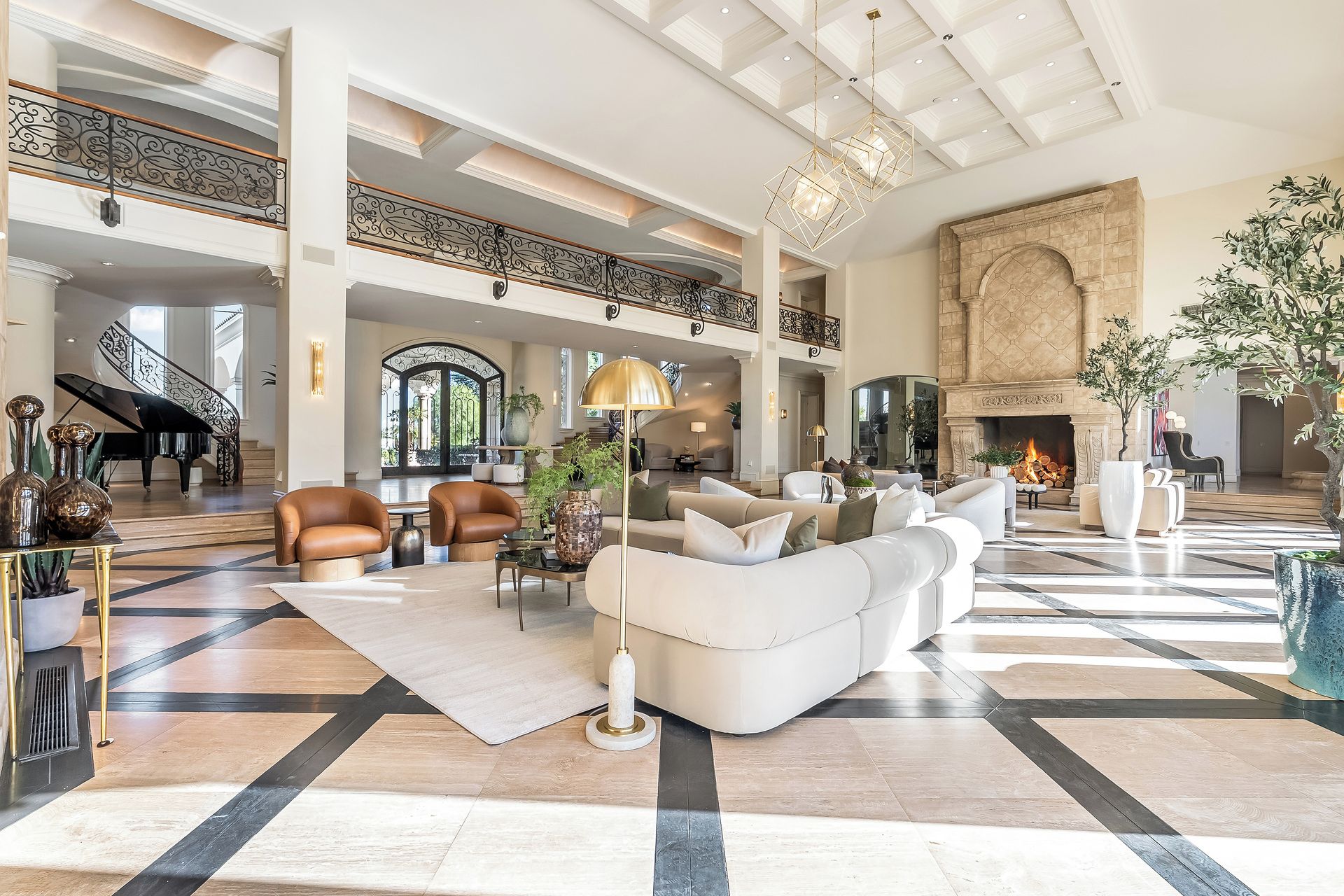 A spacious living area with a grand piano, a fireplace, and a high ceiling with skylights.