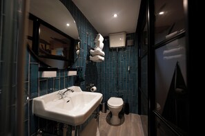 A modern bathroom with a sink, toilet, and a mirror. - Riva Boutique Hotel & Restaurant (Helensburgh)
